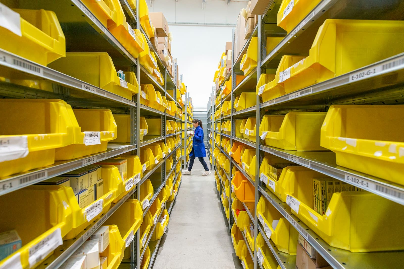 Warehouse aisle with neatly organized yellow inventory totes